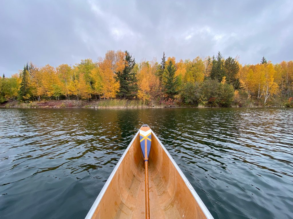 beautiful yellow fall colors can be seen from this canoe POV
